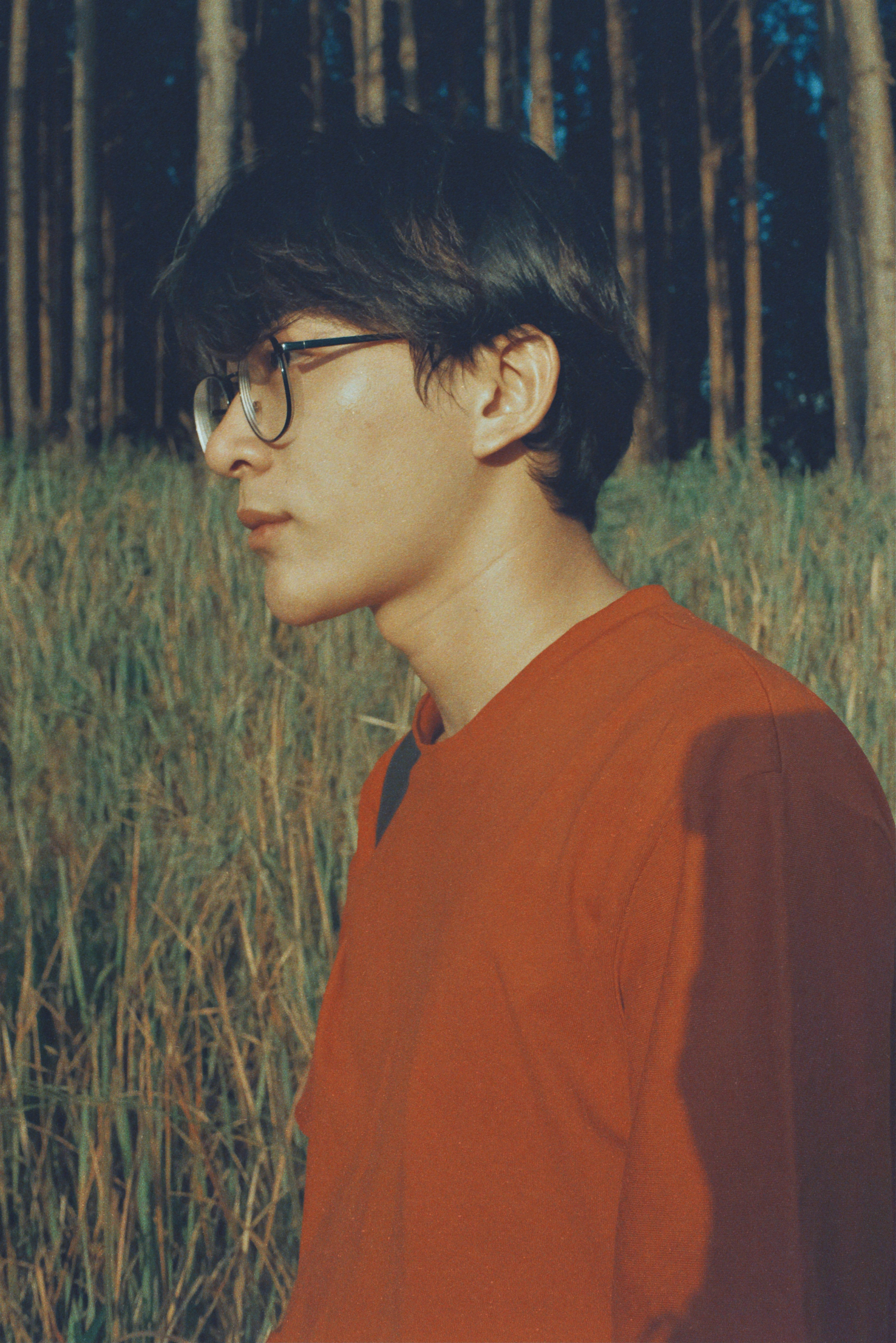 man in orange crew neck shirt wearing black framed eyeglasses